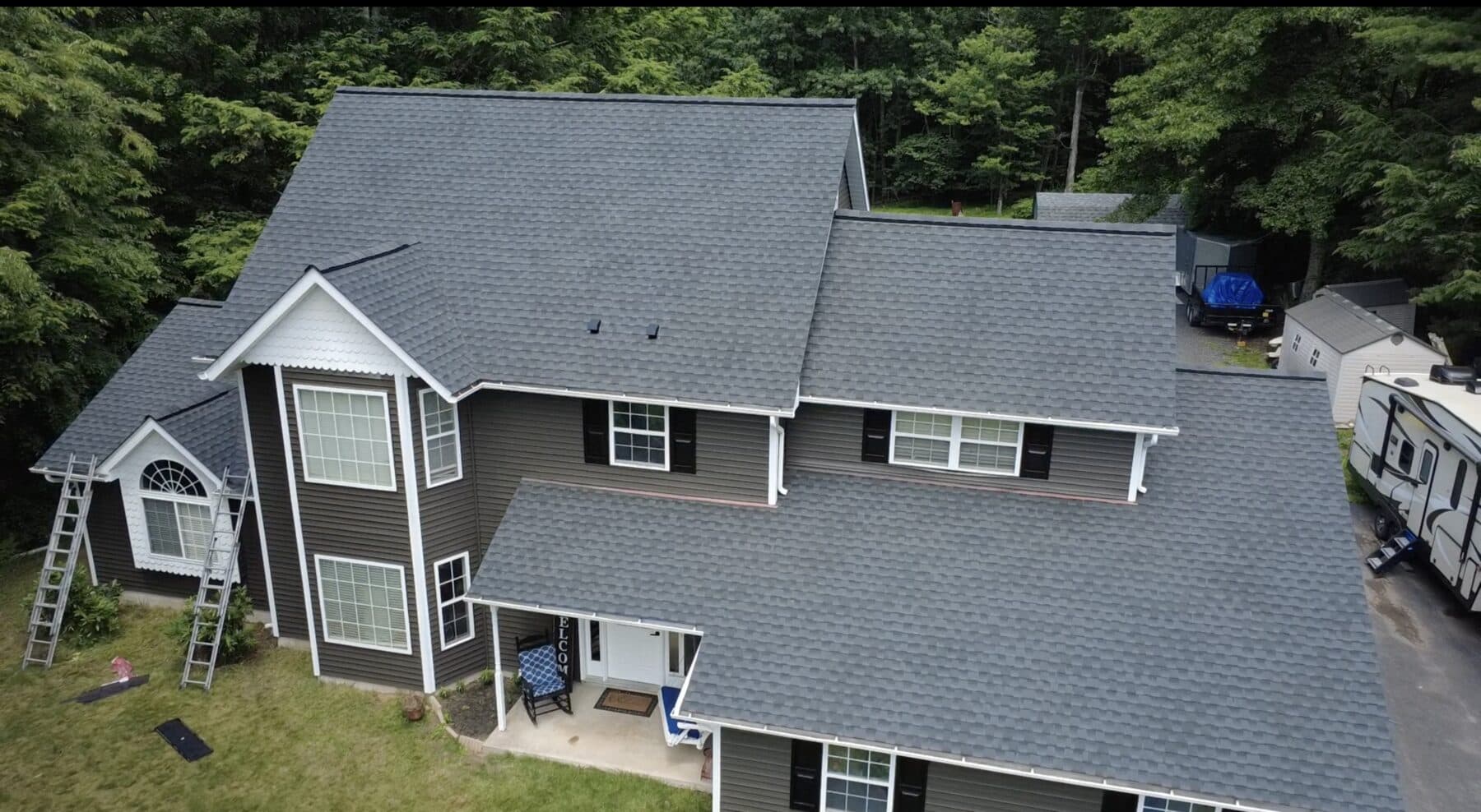 After — Monroe County roof replacement showing underlayment during installation and the finished shingle roof