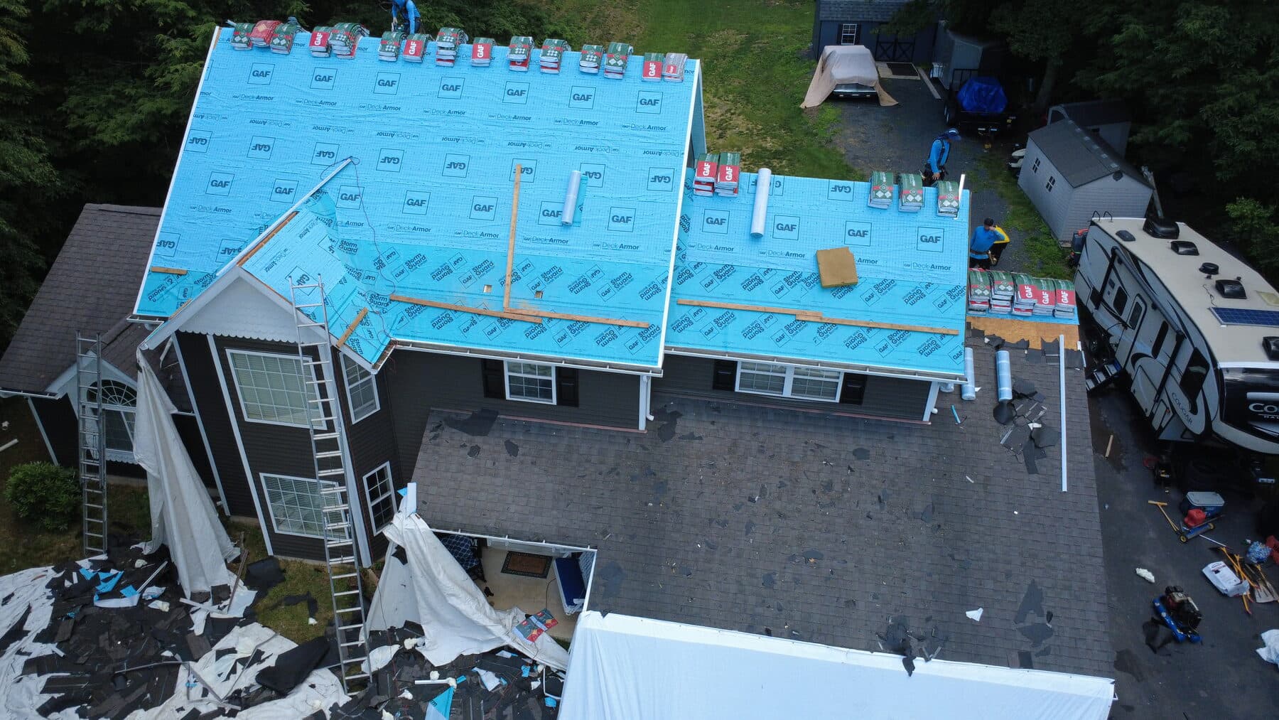 Before — Monroe County roof replacement showing underlayment during installation and the finished shingle roof