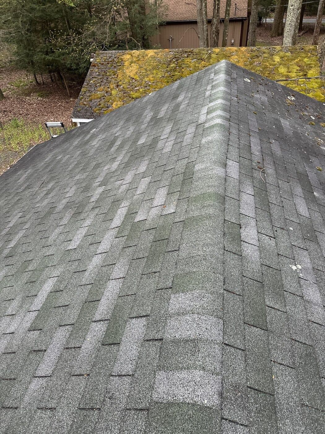 Close inspection photo showing shingle wear and ridge detail on a Poconos roof