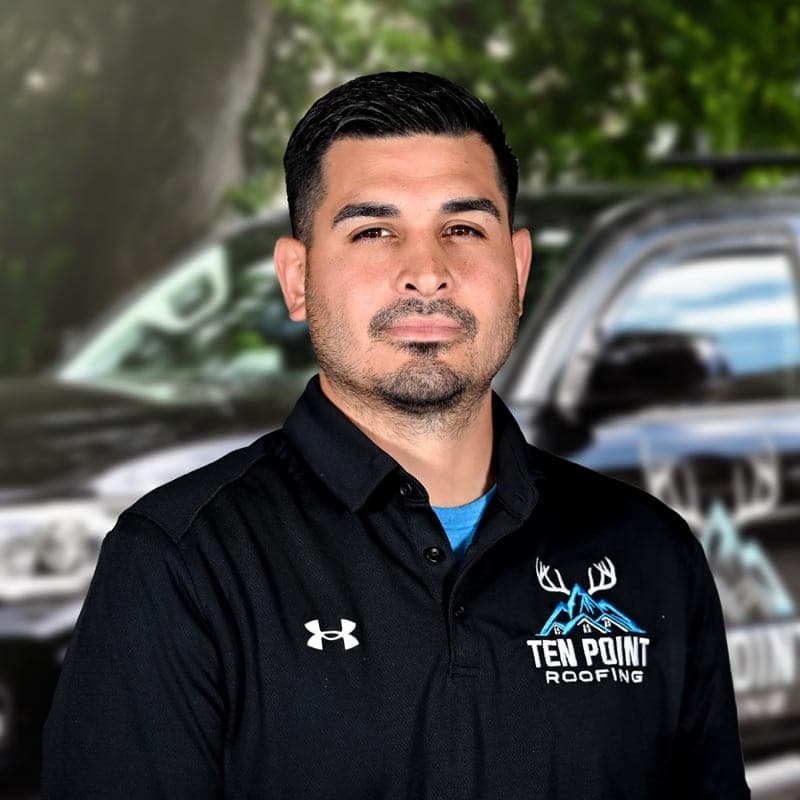 Stephen Vazquez, owner of Ten Point Roofing, in a branded polo in front of the company truck